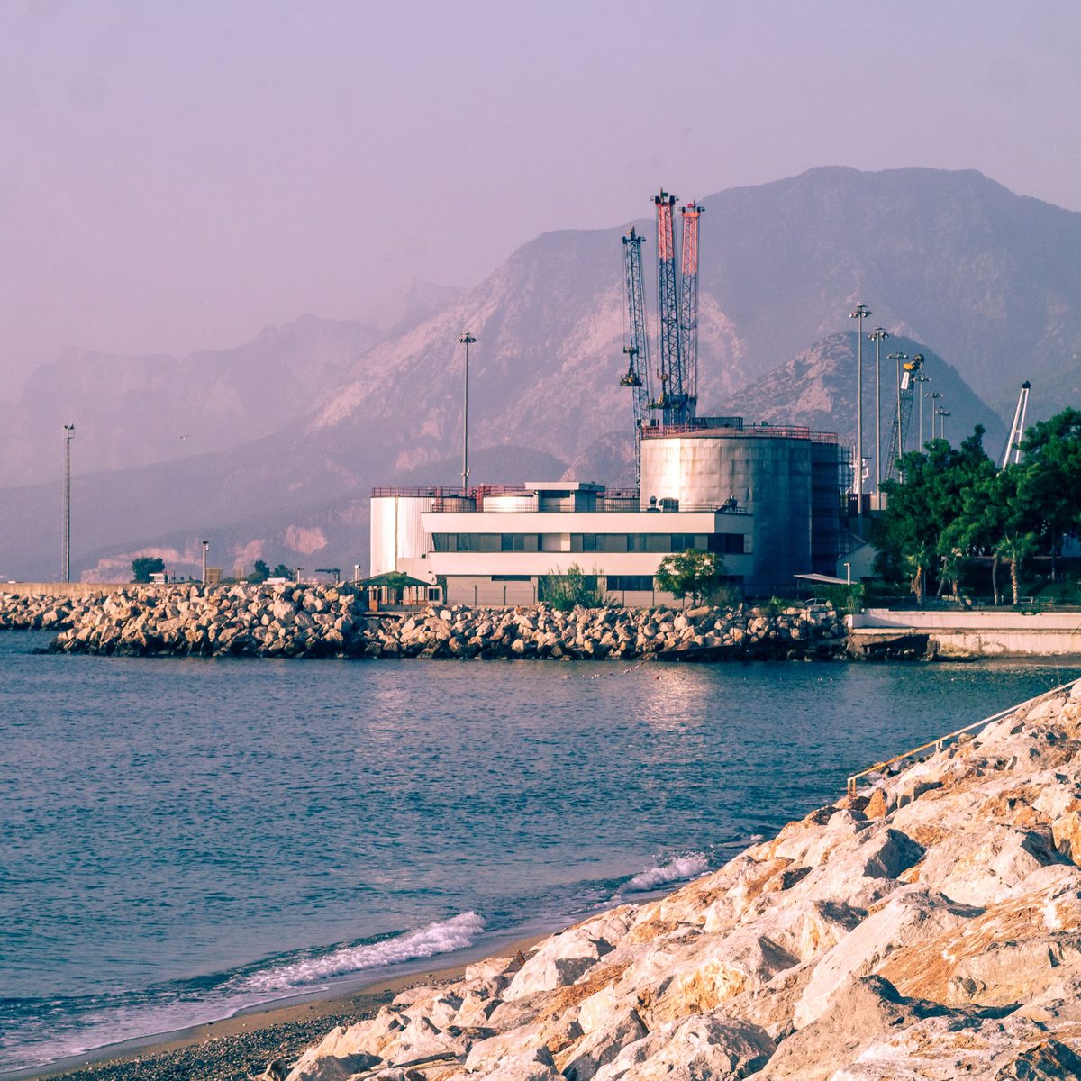 Coastal fuel storage terminal set against mountains and the sea