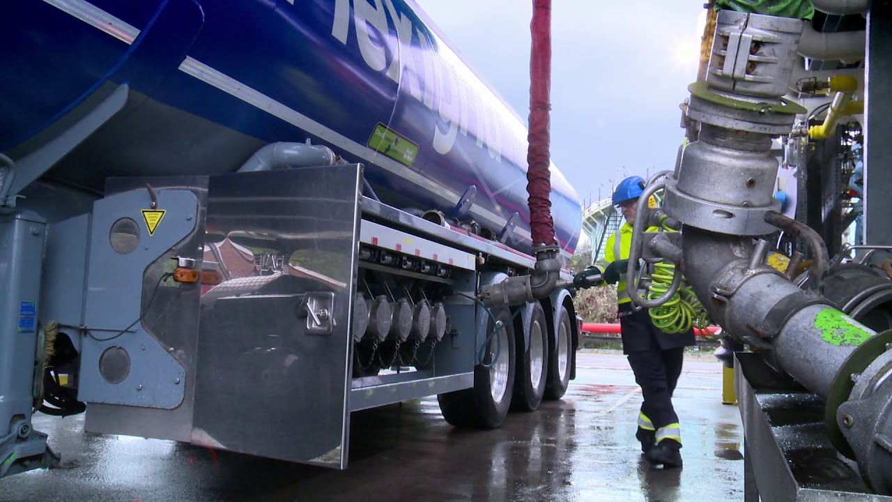 Operator connecting a loading arm to a road tanker at the terminal truck rack